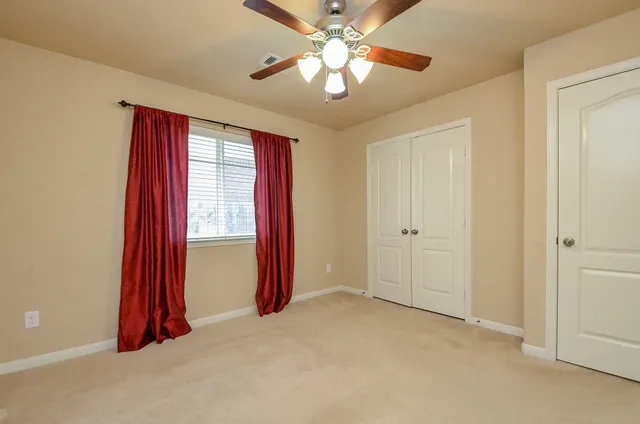 a view of a room with a chandelier fan and a bathroom