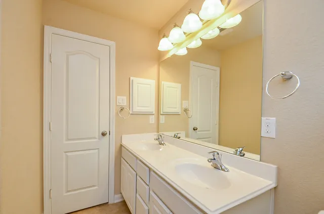 a bathroom with a sink a light fixture and a mirror
