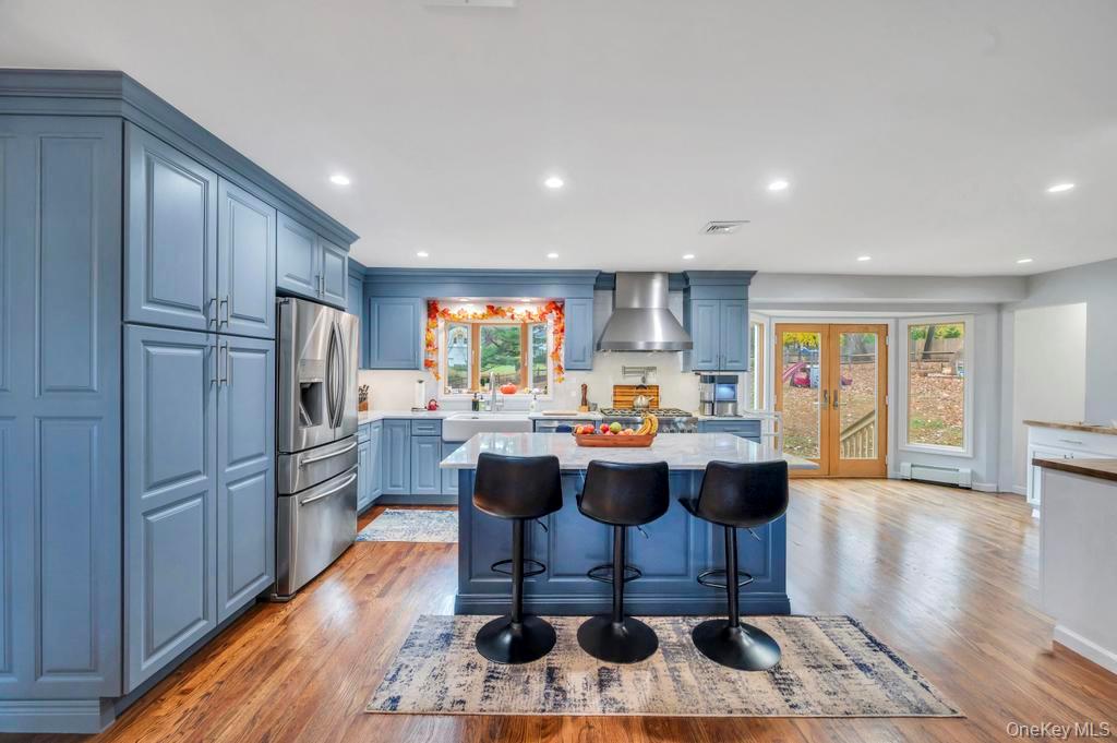 39 Bevin Road Northport, NY 11768 - Photo 11 of 44 Kitchen with blue cabinets, a kitchen island, a breakfast bar area, and recessed lighting