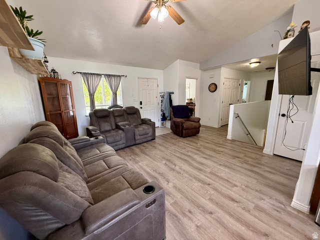 1353 360 West Payson, UT 84651 - Photo 4 of 16 Spacious living area featuring light wood-finish flooring, vaulted ceilings, and a ceiling fan with integrated lighting