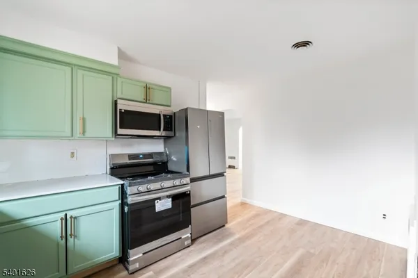 a kitchen with stainless steel appliances a stove a microwave and sink