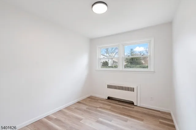 a view of a room with wooden floor and window