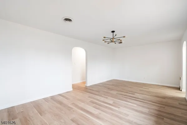a view of a room with wooden floor and a ceiling fan