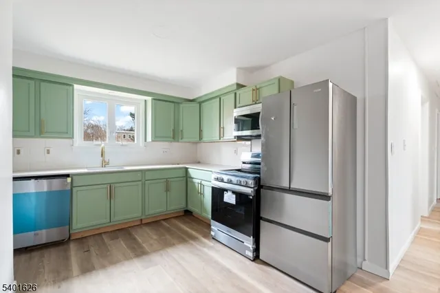 a kitchen with stainless steel appliances granite countertop a refrigerator and a sink