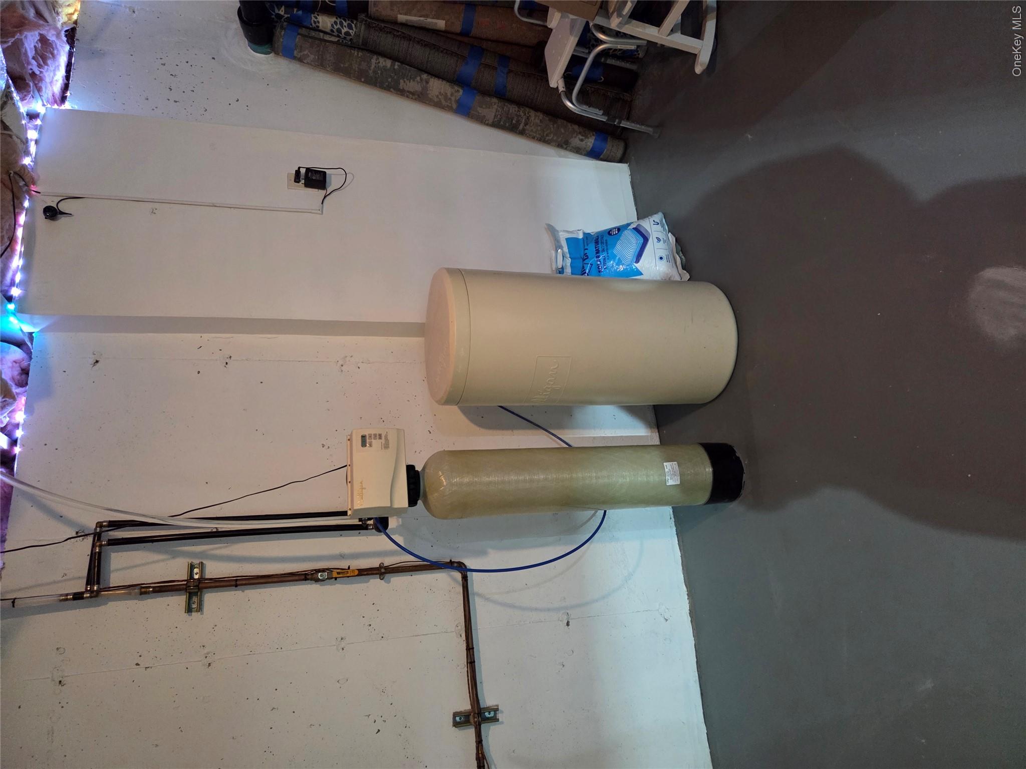 49 Aveonis Court, Unit 49 Fishkill, NY 12524 - Photo 24 of 24 Water treatment system with associated plumbing, featuring a cylindrical filter and a separate tank
