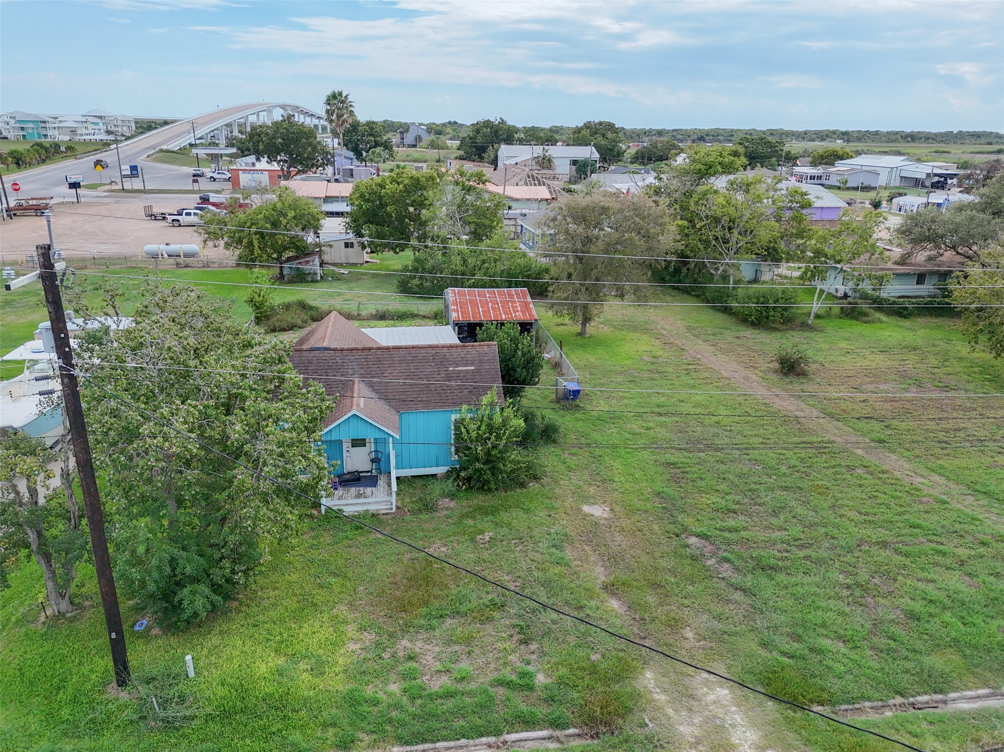 an aerial view of residential houses with outdoor space and trees