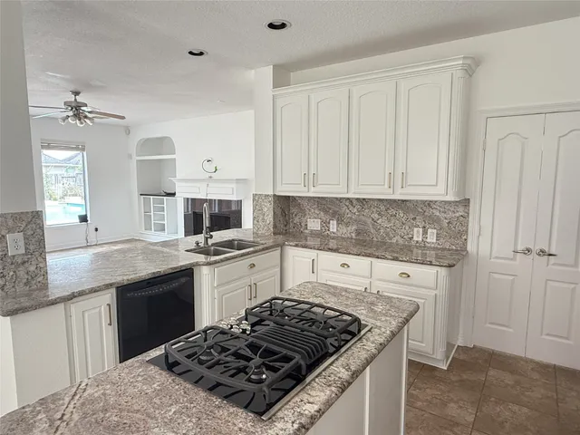 a kitchen with a stove and white cabinets