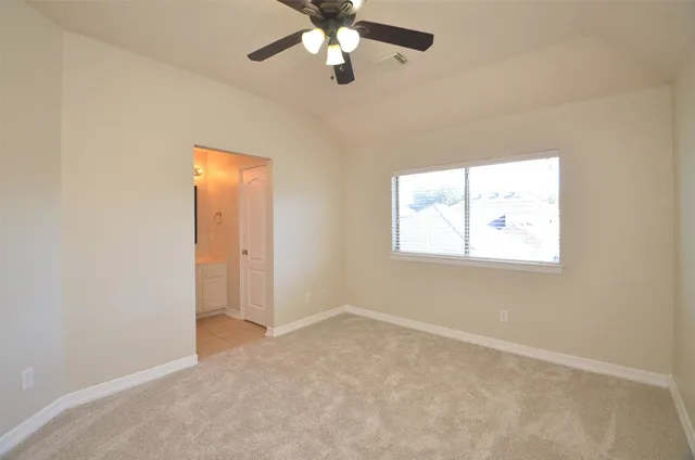 an empty room with windows and fan