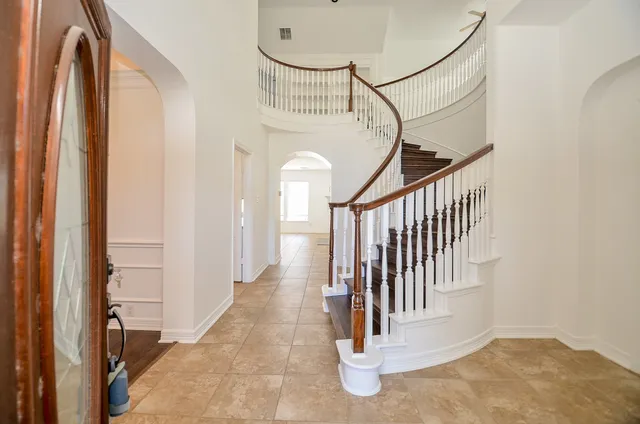 a view of a hallway with wooden floor and entryway