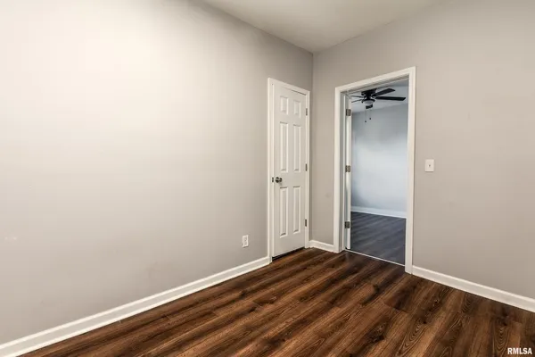 a view of a room with wooden floor and a bathroom