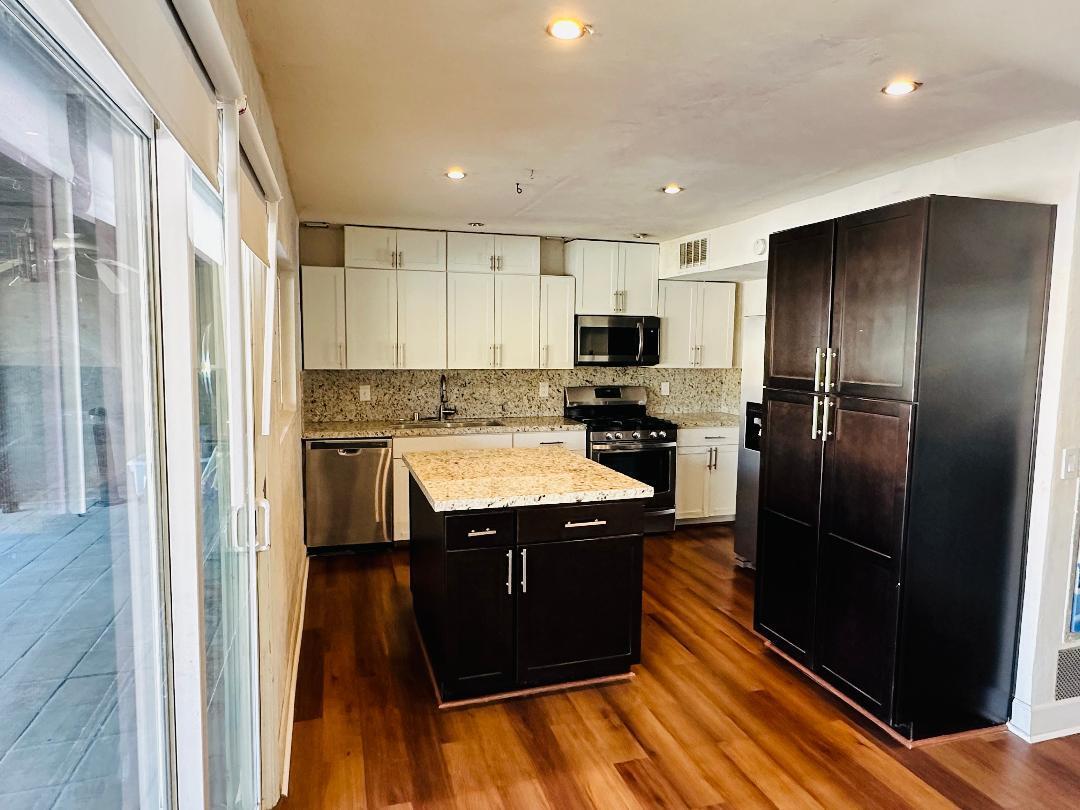 71600 Halgar Road Rancho Mirage, CA 92270 - Photo 3 of 10 a kitchen with stainless steel appliances granite countertop a refrigerator a stove and a wooden floors