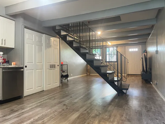 a view of a hallway with wooden floor and stairs