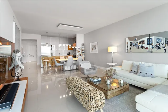 a living room with furniture a table and a view of kitchen