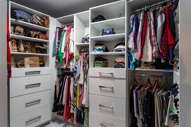 a view of walk in closet with clothes and shoes
