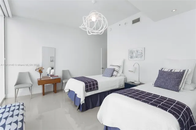 a bedroom with two beds and a chandelier