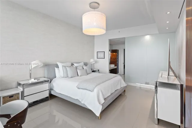 a bedroom with bed and a chandelier