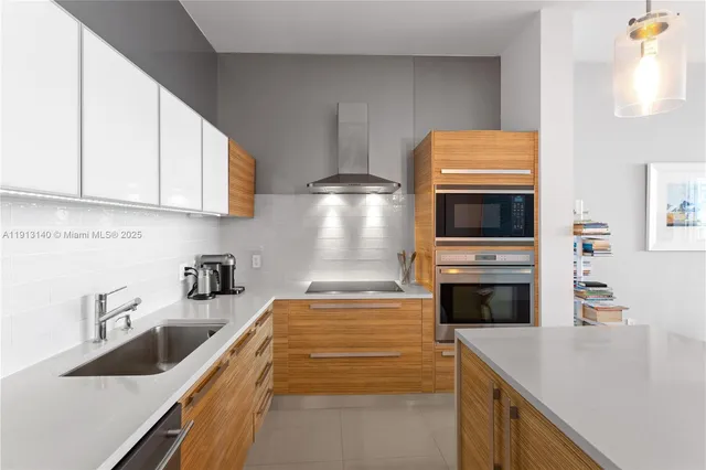 a kitchen with stainless steel appliances a stove a sink a microwave and cabinets
