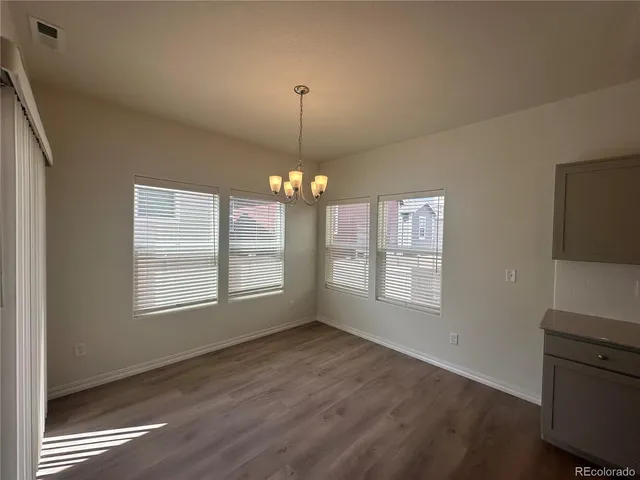 a kitchen with stainless steel appliances granite countertop a refrigerator a stove a sink dishwasher and a refrigerator with wooden floor