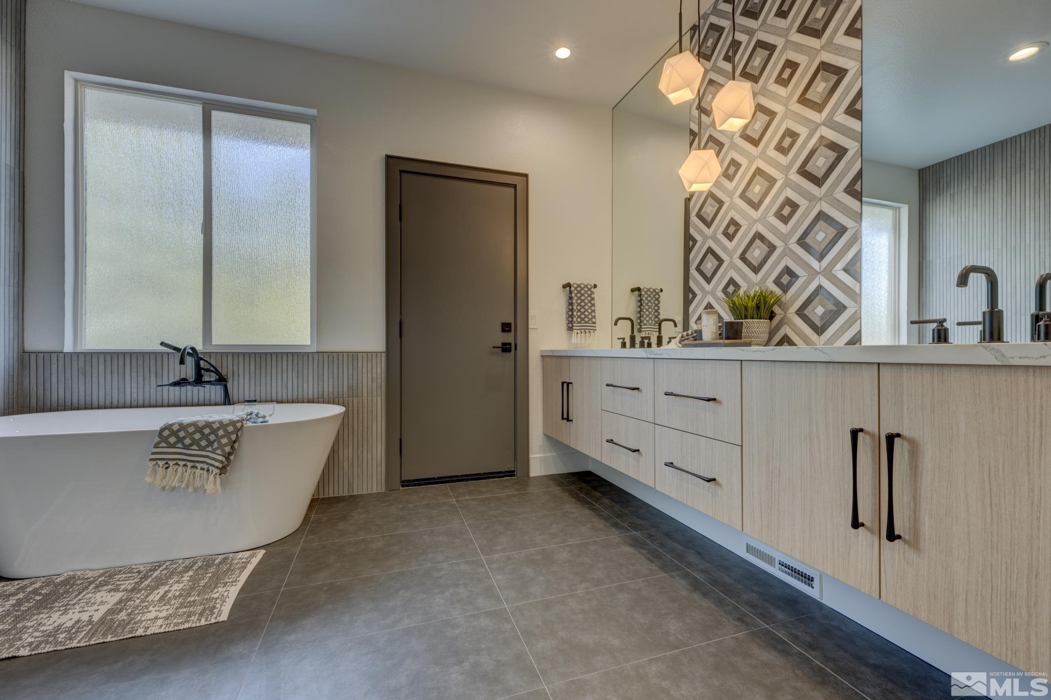 1095 Flanders Road Reno, NV 89511 - Photo 18 of 39 a bathroom with a tub sink and mirror