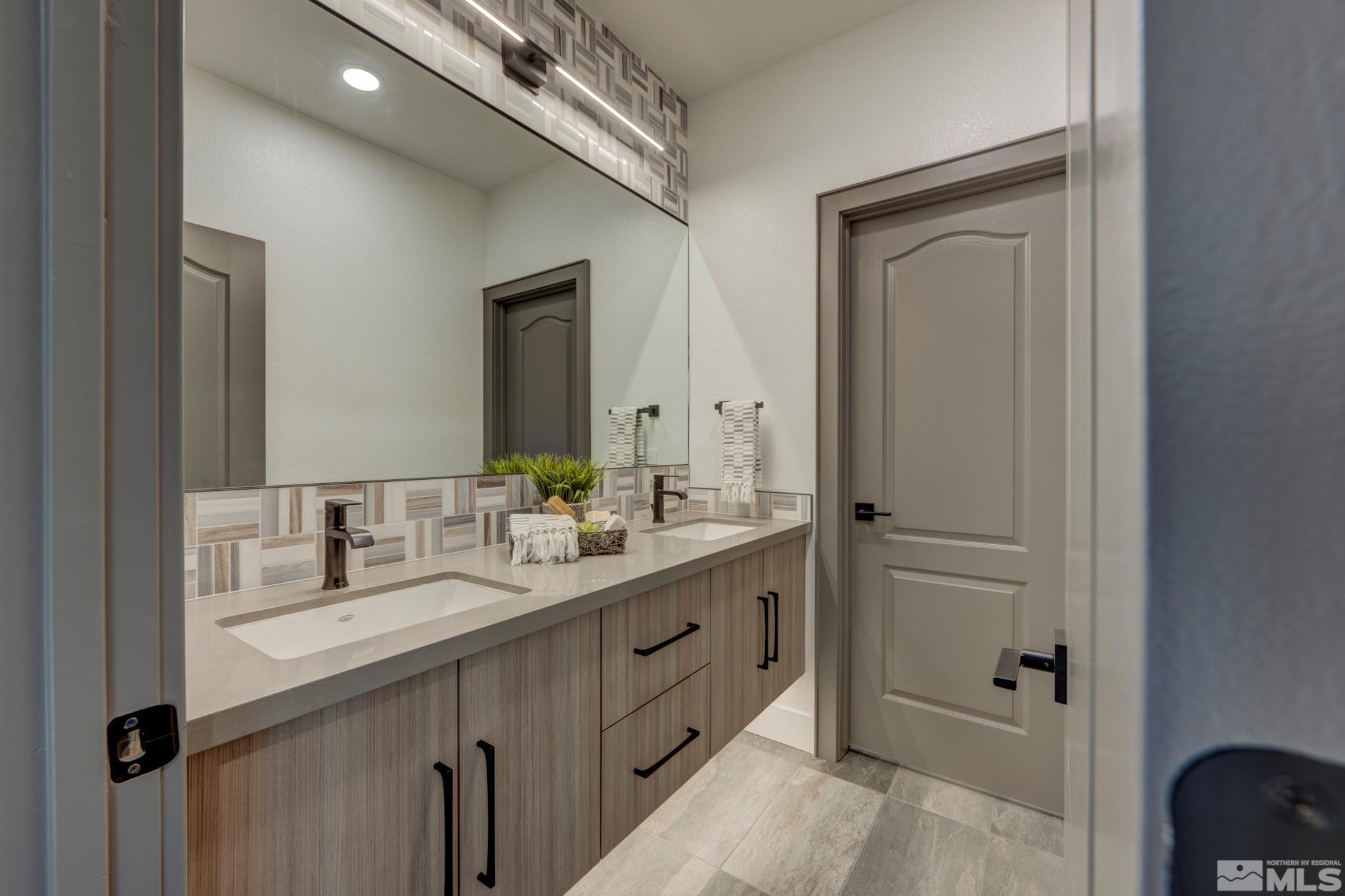 1095 Flanders Road Reno, NV 89511 - Photo 23 of 39 a bathroom with a double vanity sink and mirror