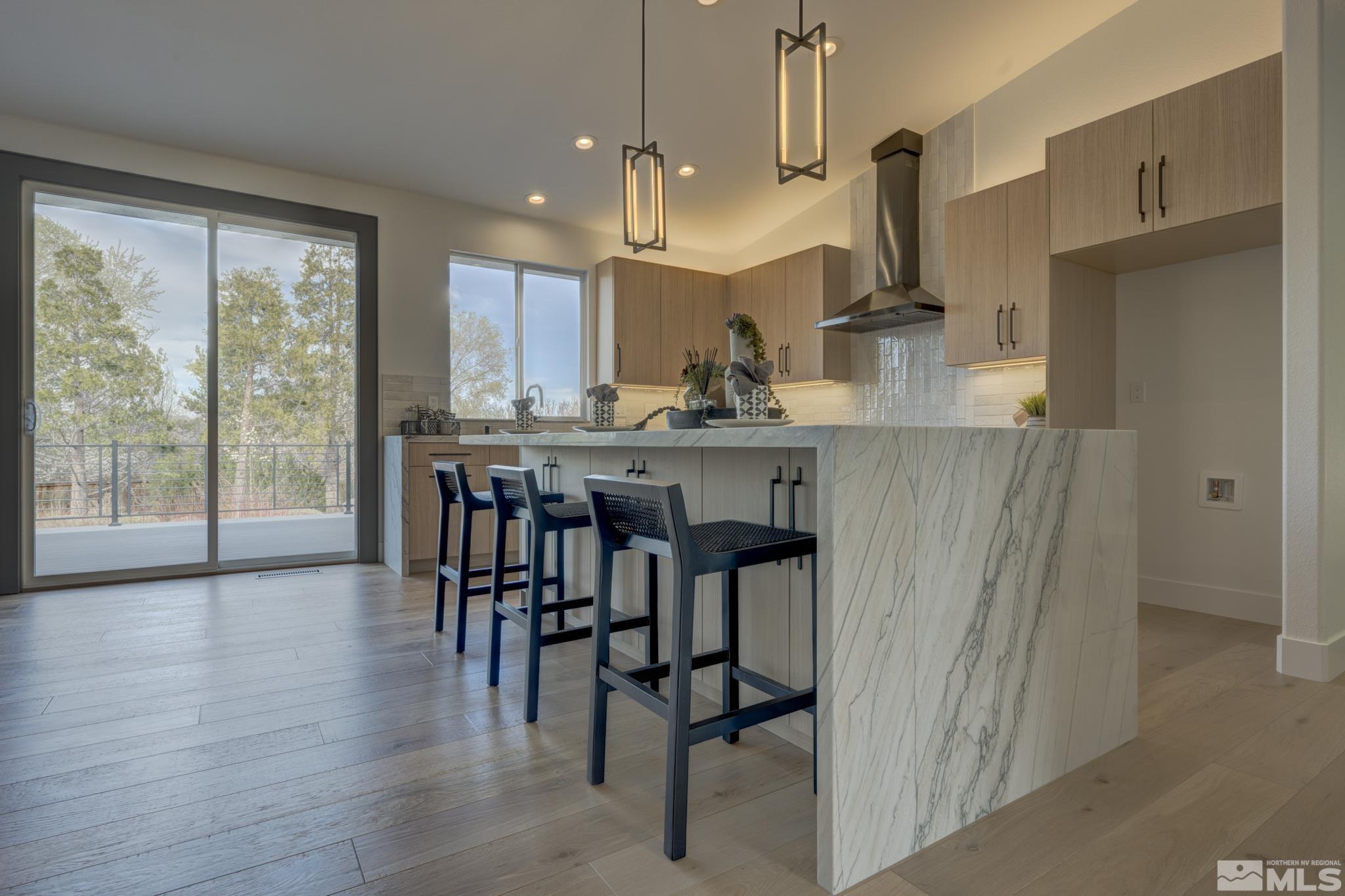 1095 Flanders Road Reno, NV 89511 - Photo 9 of 39 a kitchen with stainless steel appliances a dining table chairs and wooden floor