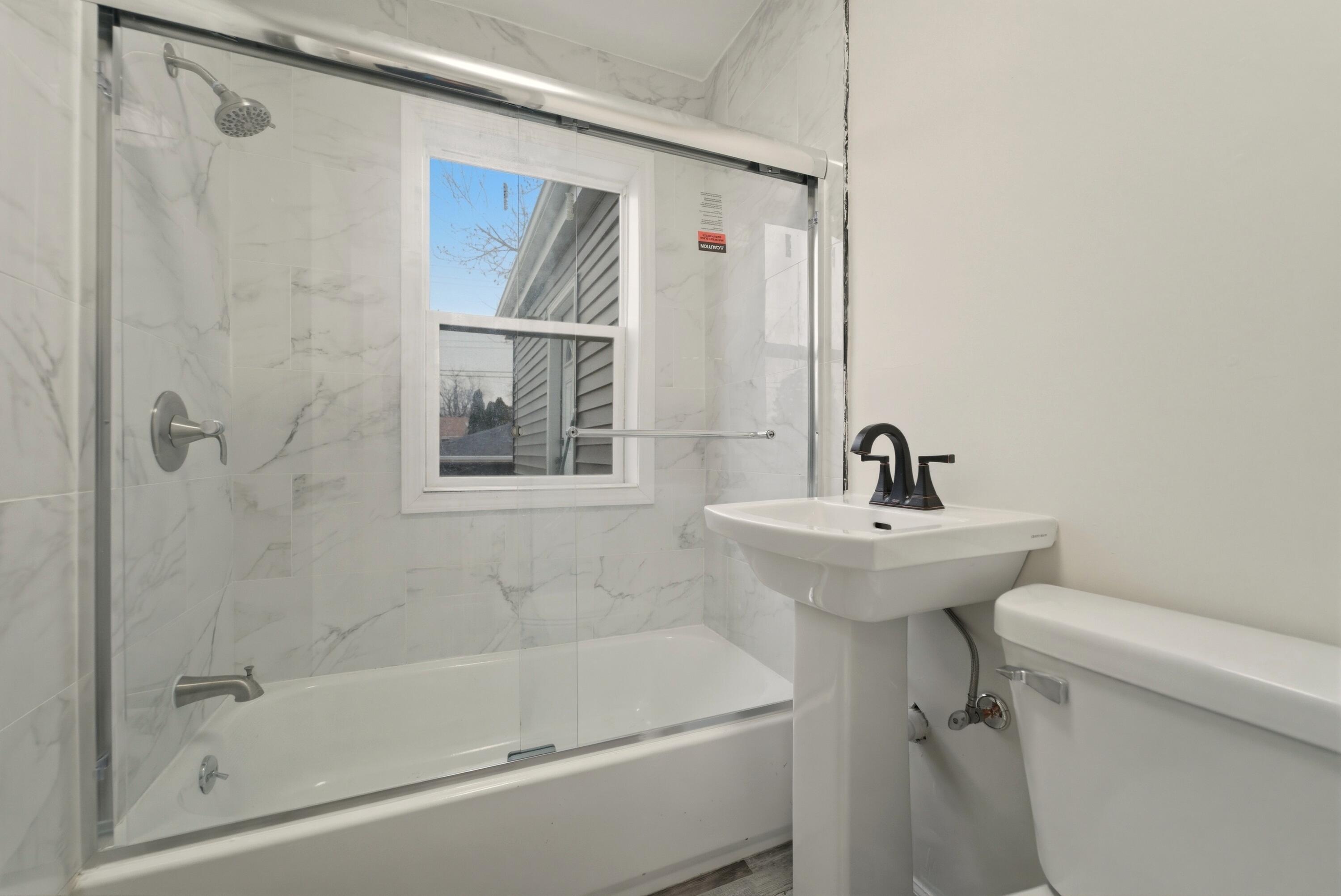 747 North Lafayette Street Griffith, IN 46319 - Photo 16 of 31 a bathroom with a sink a mirror a toilet and bathtub