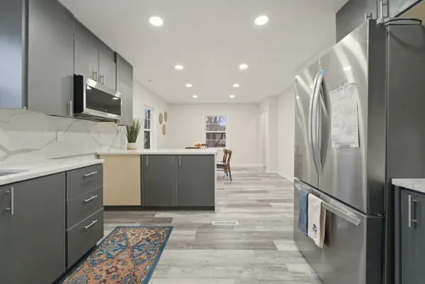 a kitchen with stainless steel appliances kitchen island granite countertop a refrigerator and a sink