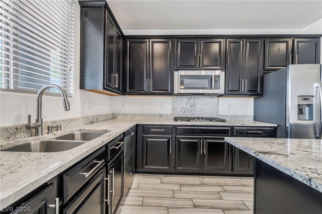 6245 Andover Wood Road Las Vegas, NV 89113 - Photo 10 of 37 A well-appointed kitchen features dark cabinetry, ample counter space, and stainless steel appliances.