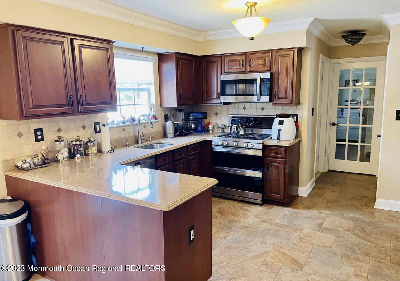 16 William Drive Howell, NJ 07731 - Photo 5 of 25 a kitchen with stainless steel appliances granite countertop a stove a sink a microwave and a refrigerator