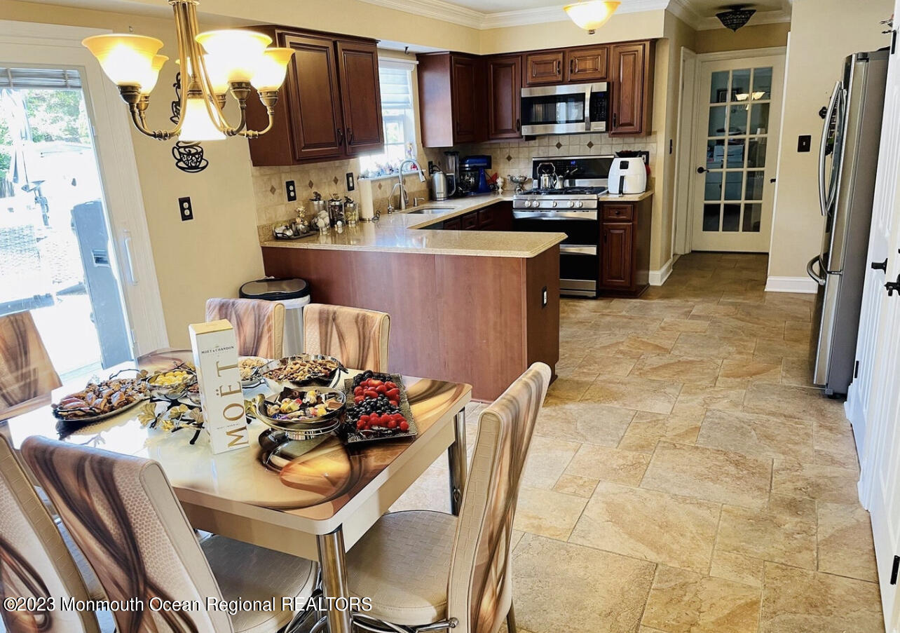 16 William Drive Howell, NJ 07731 - Photo 7 of 25 a kitchen with stainless steel appliances granite countertop a stove a sink dishwasher and a refrigerator with wooden cabinets