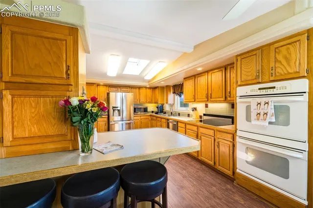 a kitchen with a table chairs stove and refrigerator