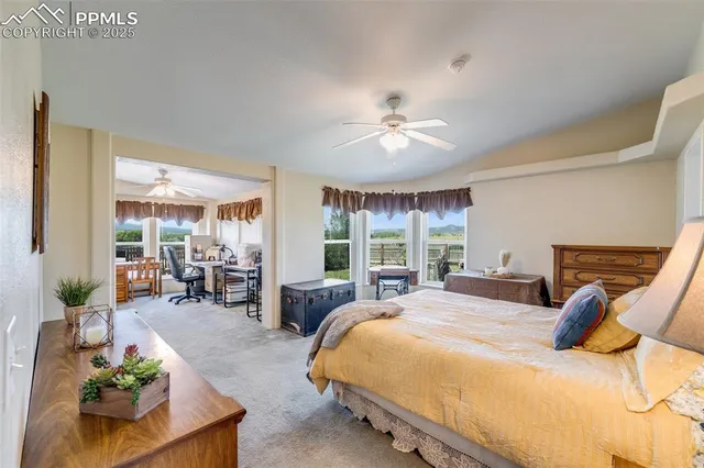 a bedroom with a bed and large windows