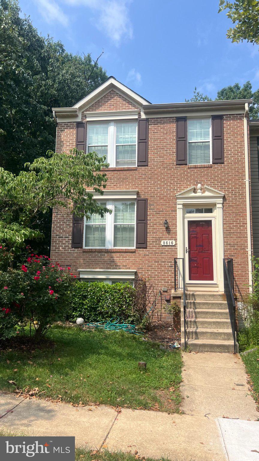 Charming brick home with vibrant garden.