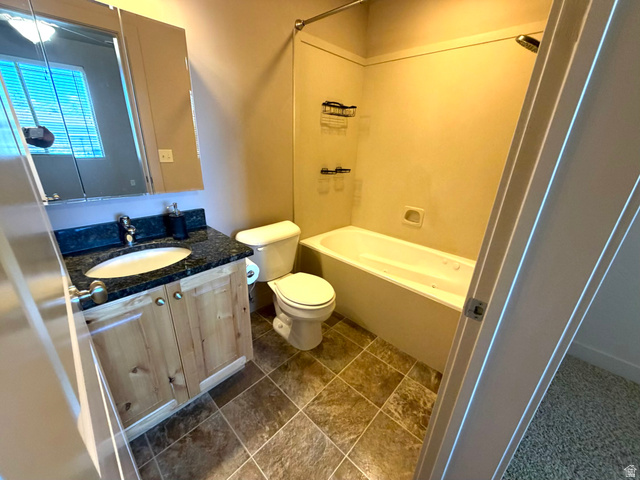 3618 Clear Rock Road, Unit 2 Eagle Mountain, UT 84005 - Photo 9 of 14 Bathroom featuring a vanity with a dark countertop, an undermount sink, and wood-finish cabinetry
