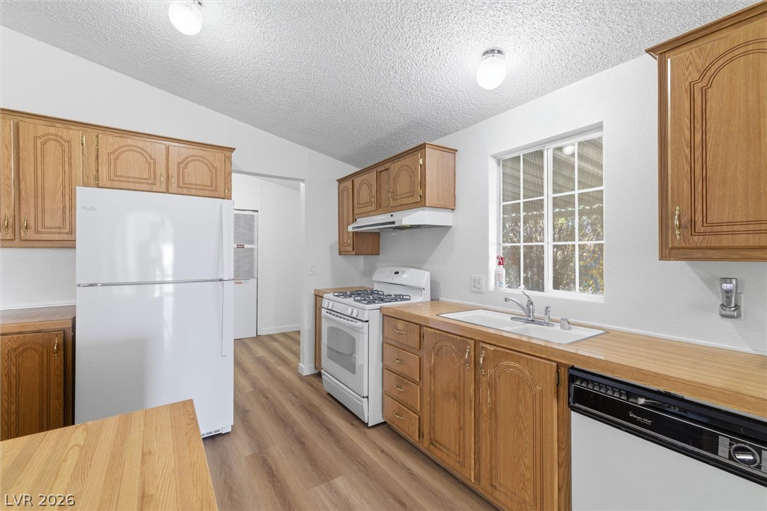 20 Rudy Road Pahrump, NV 89048 - Photo 15 of 32 Oak cabinets pair with durable wood-look flooring in this functional cooking space.