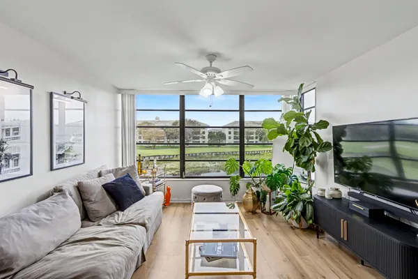 a living room with furniture large window and flat screen tv
