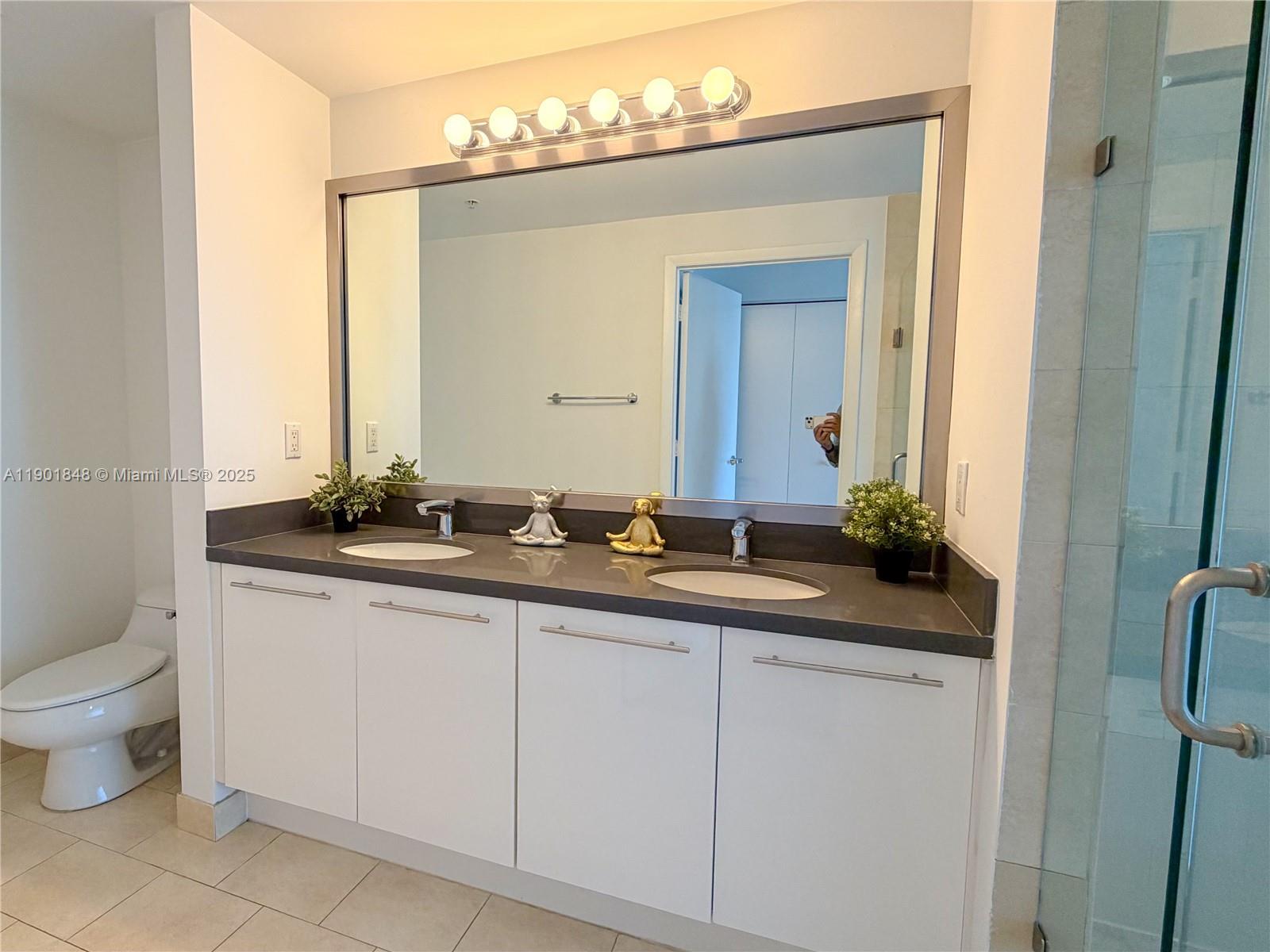 90 Southwest 3rd Street, Unit 2401 Miami, FL 33130 - Photo 26 of 68 a bathroom with a toilet sink and mirror