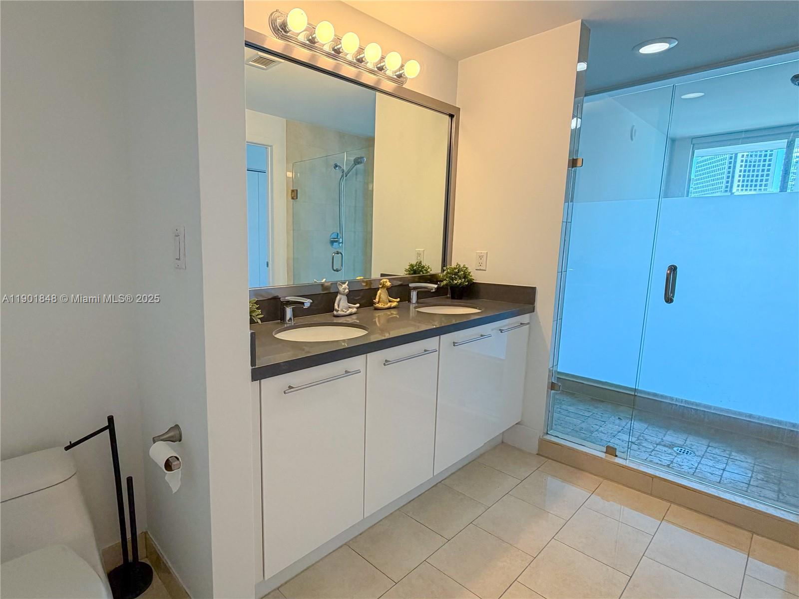 90 Southwest 3rd Street, Unit 2401 Miami, FL 33130 - Photo 27 of 68 a spacious bathroom with a sink a mirror and a shower