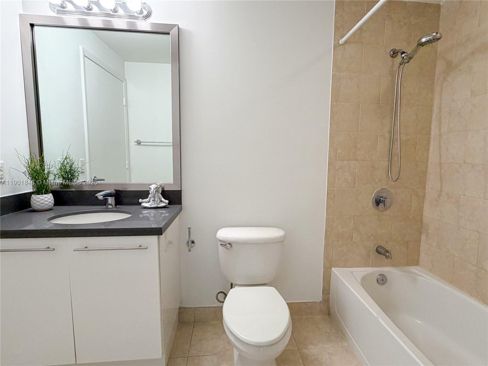 90 Southwest 3rd Street, Unit 2401 Miami, FL 33130 - Photo 38 of 68 a bathroom with a granite countertop sink a toilet a mirror and bathtub