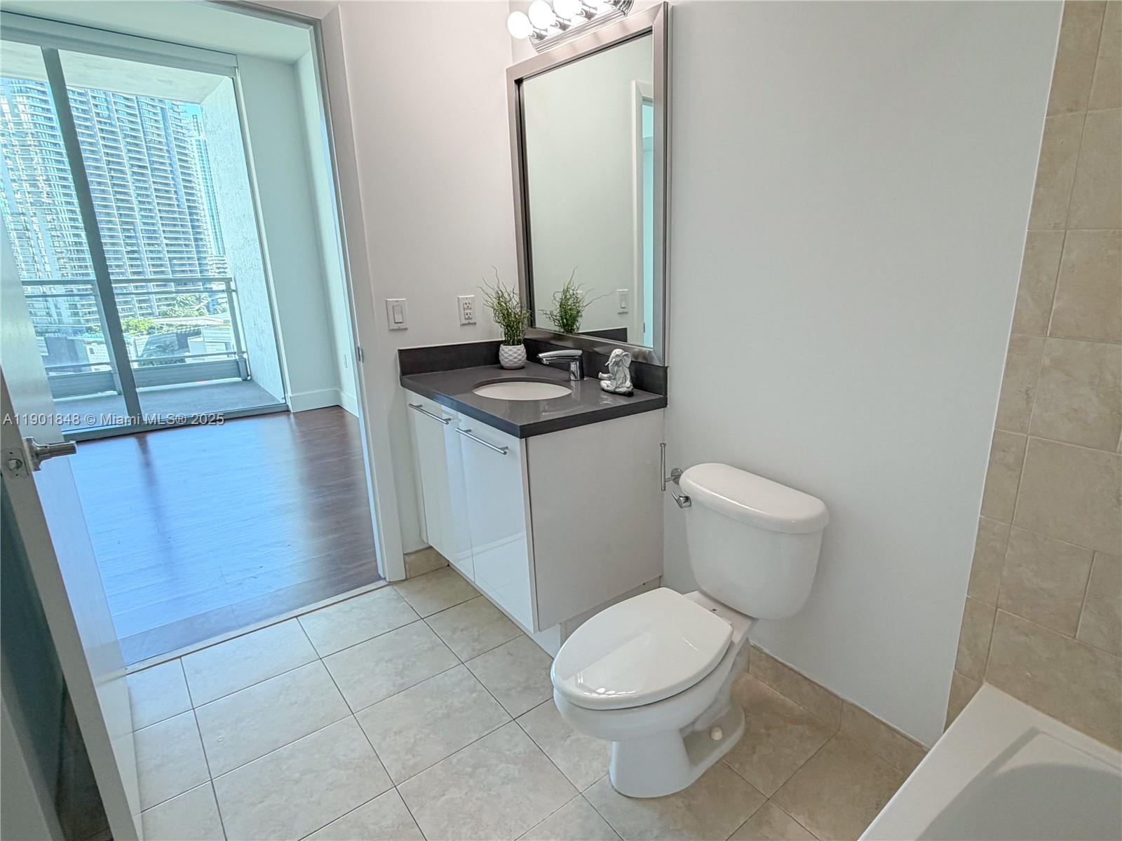 90 Southwest 3rd Street, Unit 2401 Miami, FL 33130 - Photo 39 of 68 a bathroom with a toilet a sink and a mirror