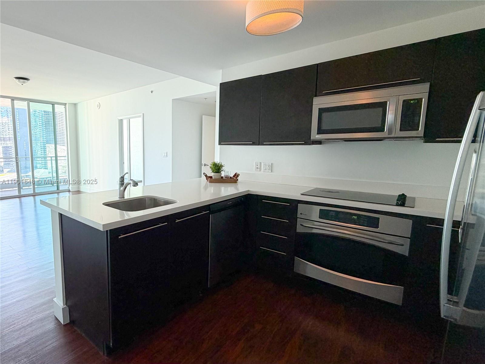 90 Southwest 3rd Street, Unit 2401 Miami, FL 33130 - Photo 7 of 68 a kitchen with a sink and stainless steel appliances