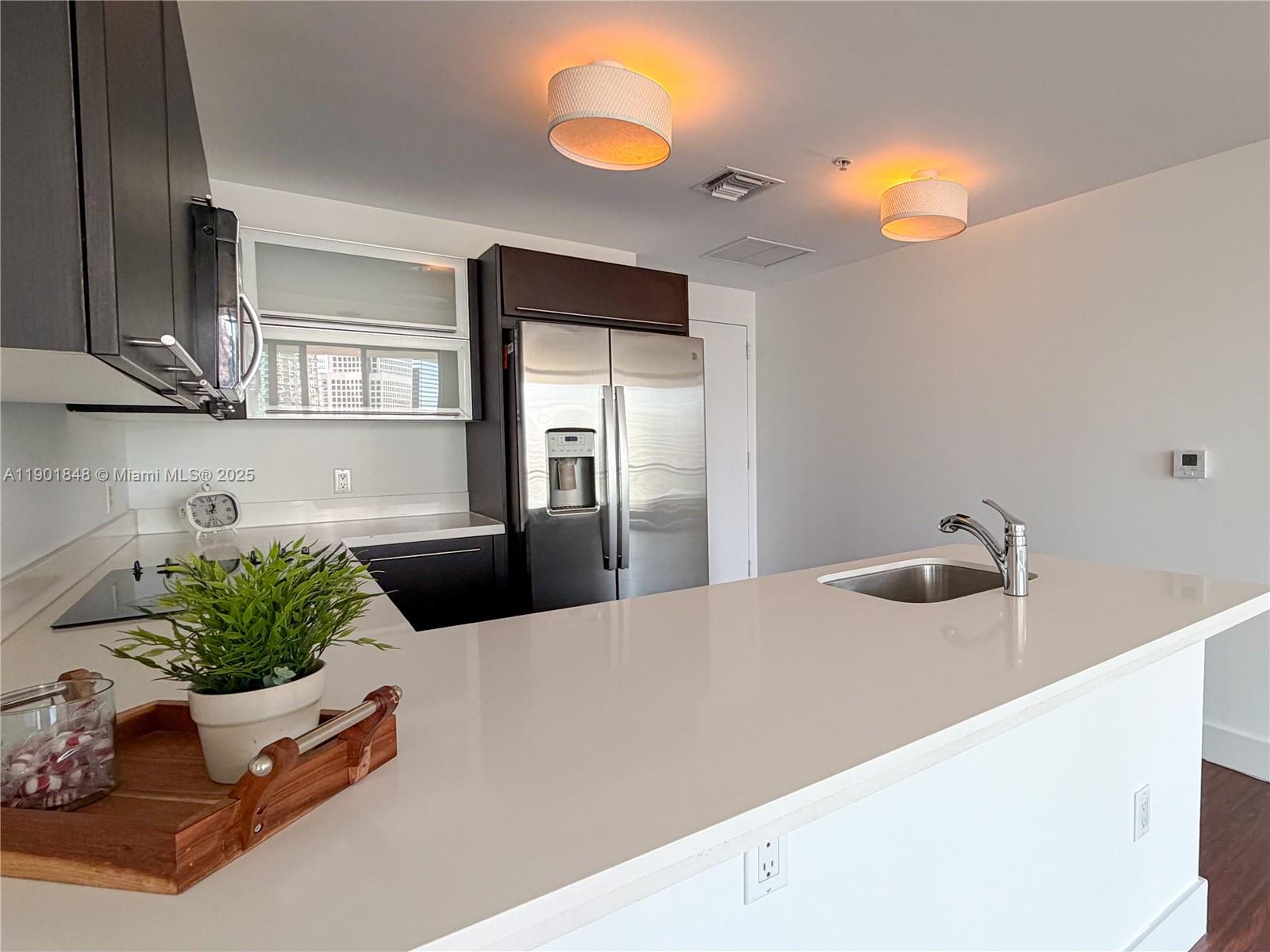 90 Southwest 3rd Street, Unit 2401 Miami, FL 33130 - Photo 9 of 68 a kitchen with a sink and a refrigerator