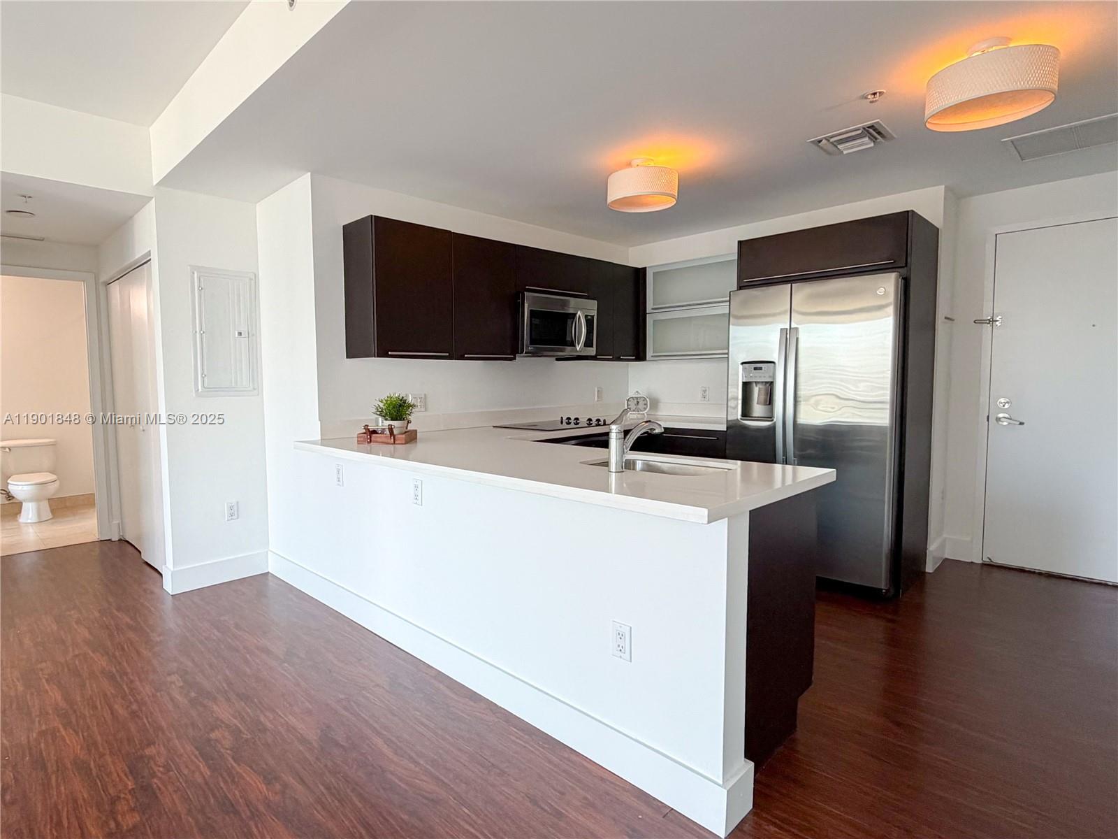 90 Southwest 3rd Street, Unit 2401 Miami, FL 33130 - Photo 10 of 68 a kitchen with stainless steel appliances granite countertop a sink and a refrigerator