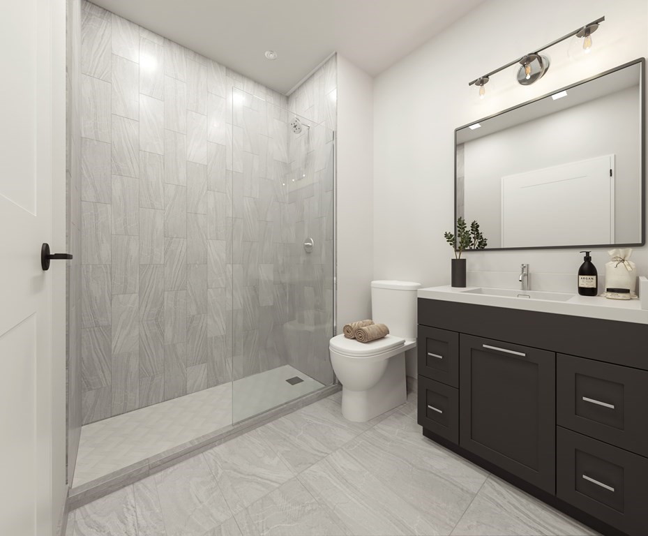 202 Maverick Street, Unit 106 Boston, MA 02128 - Photo 5 of 17 a bath room with a toilet a sink and a mirror
