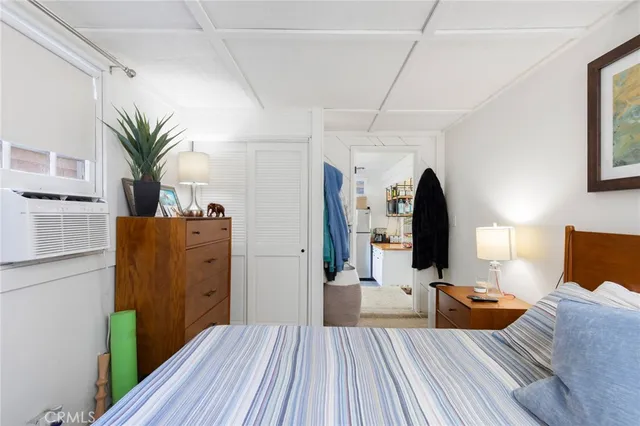 a view of a bedroom with a bed and wooden floor