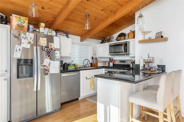 a kitchen with stainless steel appliances granite countertop a refrigerator a stove top oven a sink and dishwasher