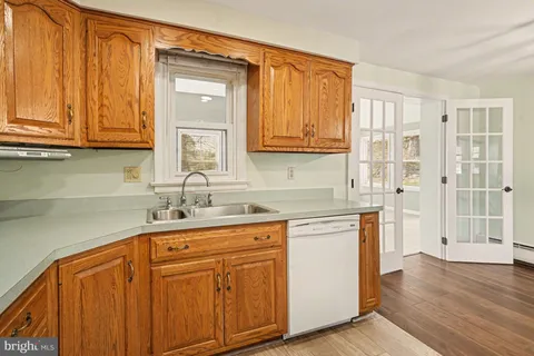 a kitchen with stainless steel appliances granite countertop a sink and cabinets with wooden floor