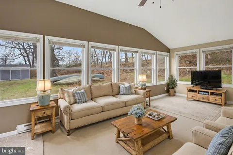 a living room with furniture a flat screen tv and a large window