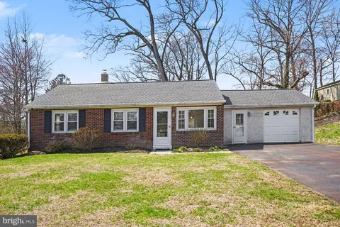a front view of house with yard and trees around