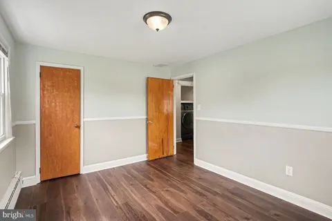 an empty room with wooden floor and closet